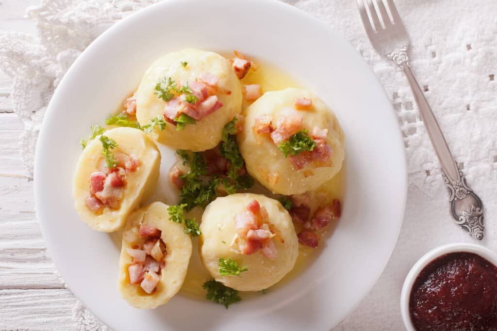 potato dumplings with bacon close up and lingonberry sauce. hori
